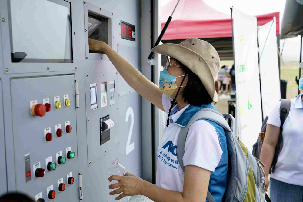 志工們將拾起的寶特瓶投入「好歸塑專車」，讓廢棄塑料空瓶可以直接粉碎、縮小體積，未來將可再製成購物袋、寶特衣、悠遊卡等生活用品